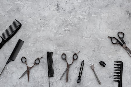 Hairdresser workplace. Combs and sciccors on grey table background top view.の写真素材