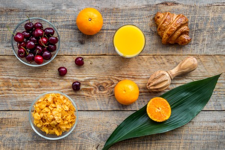 Light summer breakfast. Muesli, fruits and berries on wooden table background top view.の写真素材