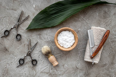 Preparing for men shaving. Shaving brush and razor on grey stone table background top view.の写真素材