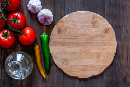 Mockup for menu. Cutting board and vegetables on wooden table background top viewの写真素材