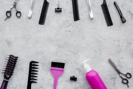 Hairdresser workplace. Combs, sciccors and hairdressing tools on grey table background top view.