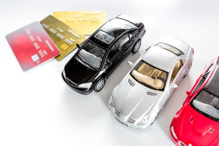 Choosing car concept. Toy cars and bank card on white background top view copyspace.の写真素材