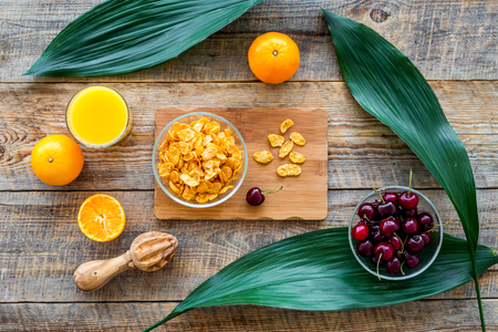 Light summer breakfast. Muesli, fruits and berries on wooden table background top view.の写真素材