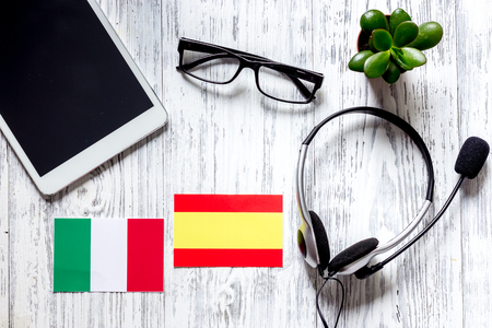 Self-development. Learning languages online. Headphones and tablet PC on wooden background top view mockupの写真素材