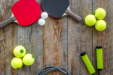 Sport background. Sport gear. Table tennis racket, tennis balls, hand expander on wooden background top view copyspaceの写真素材