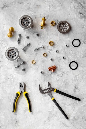 Sink drain parts and plumbing tools on grey stone background top viewの写真素材