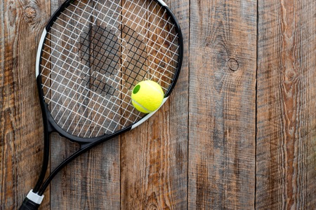 Sport background. Tennis balls and racket on wooden background top view.の写真素材