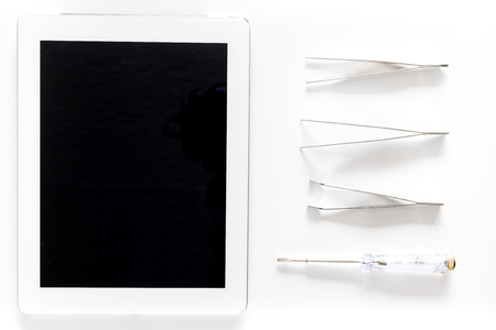 Daignostic of gadgets. Tablet computer and tools on white background top view mockupの写真素材
