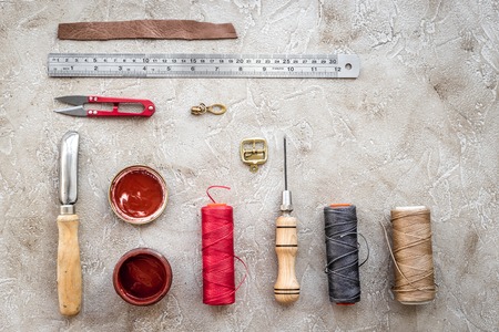 Leather workshop. Tanner's tools on grey stone background top view.の写真素材