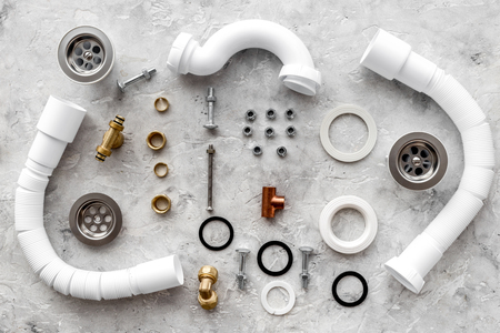 Drain parts and plumbing tools on grey stone background top view.の写真素材