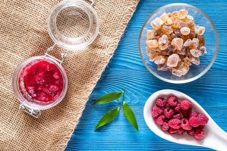 Homemade natural jam. Berries and sugar on blue wooden and canvas background top viewの写真素材