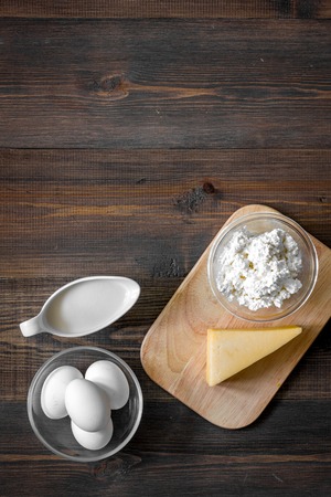 Natural food. Milk, cottage, cheese, eggs on dark wooden background top view copyspaceの写真素材