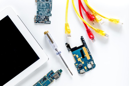 Repairing gadgets. Parts, wires and tools on white background top viewの写真素材