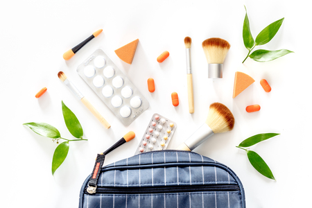 Beauty bag with cosmetics, contraceptives and pills on white table background top viewの写真素材