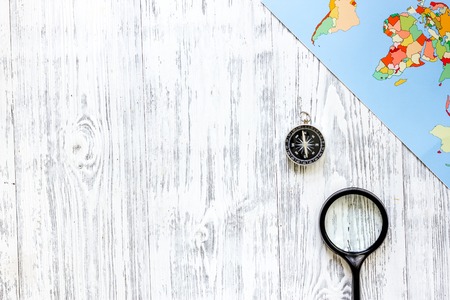 Planning trip. World map and compass on wooden table background top view copyspaceの写真素材