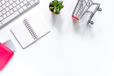 Shopping in webstore. Shopping cart, bank card and keyboard on white background top view copyspaceの写真素材