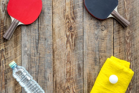 Sport background. Traning cocept. Ping pong racket, towel and water on wooden background top view copyspaceの写真素材