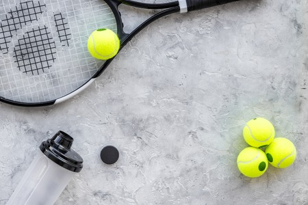 Sport background. Tennis balls and racket on grey background top view copyspaceの写真素材