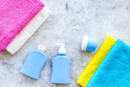 Bathroom set. Towels and bottles with soap and shampoo on grey stone backgrond top view.の写真素材