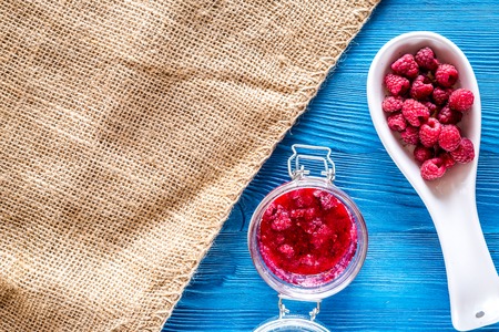 Homemade jam. Berries and sugar on blue wooden background top view.の写真素材