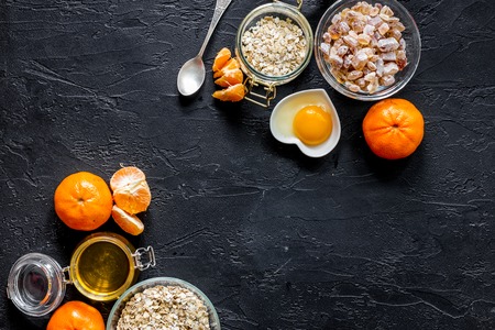 Porrige for breakfast with oranges and honey on black stone background top view.の写真素材