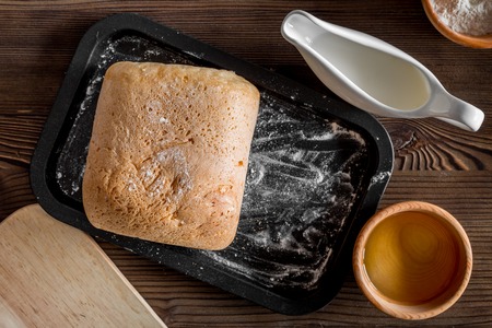 Make bread. Loaf and ingredients on dark wooden table background top viewの写真素材