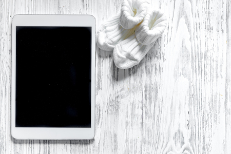 Mockup for adoption concept. Tablet PC on light wooden background top view.の写真素材