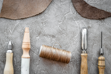 Leather craft tools on grey stone background top view.の写真素材