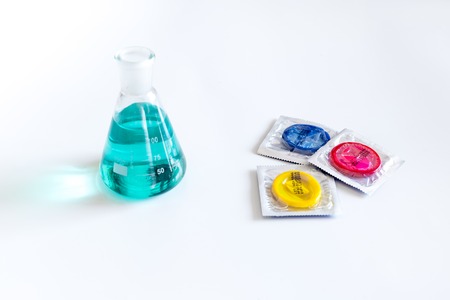 Visit the urologist. Flask and condoms on white background.の写真素材