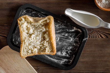 Make bread. Loaf and ingredients on dark wooden table background top view.の写真素材