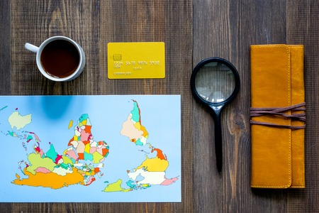 Planning trip. World map and compass on wooden table background top view.