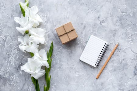 Celebration accessories. Box in kraft paper and notebook on grey stone table top view copyspaceの写真素材