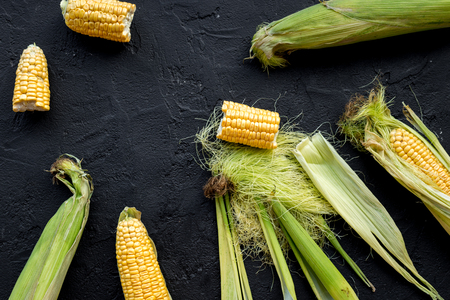 Vegetarian food. Corn cobs on rustic wooden background top view.の写真素材
