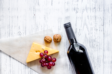 Wine snack. Cheese, nuts, grape on light wooden table background top viewの写真素材