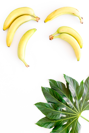Exotic fruits. Fresh ripe bananas near big tropical leaf on white background top view.の写真素材