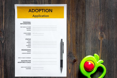 Adoption application near toy on dark wooden table background top view copyspaceの写真素材