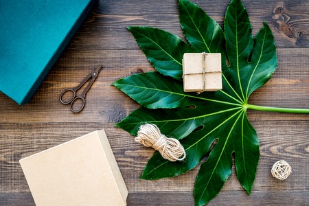 Packaging gift. Turquoise gift box, sciccors, thin cord on dark wooden background top viewの写真素材