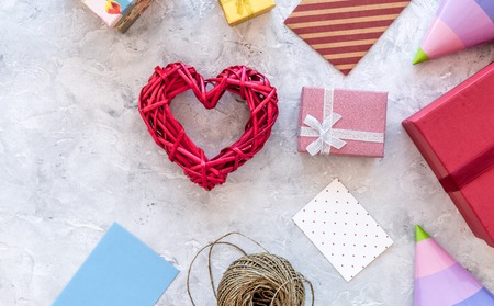 Preparing to celebration. Colored gift boxes and party hats on grey stone background top view copyspaceの写真素材
