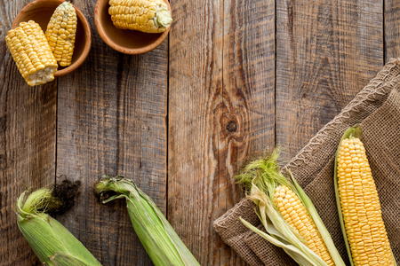 Organic farm food. Cutted corn cobs on rustic wooden background top view copyspaceの写真素材