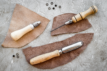 Leather craft tools on grey stone background top viewの写真素材