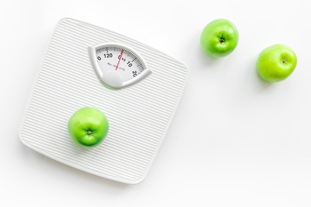 Bathroom scale and apples on white background top view.の写真素材