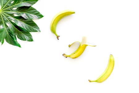 Exotic fruits. Fresh ripe bananas near big tropical leaf on white background top view.の写真素材