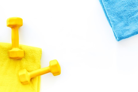 Fitness background. Dumbbells and towel on white background top view.の写真素材