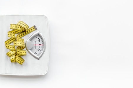 Bathroom scale and measuring tape on white background top view.の写真素材