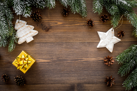 New year's background. Christmas toys, present, spruce branches, pine cones on dark wooden background top view.の写真素材