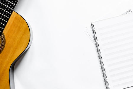 songwriter or dj work place with guitar and notebook on white desk background top view mockupの写真素材