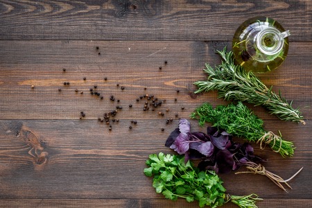 home cooking with fresh greenery and organic oil on wooden kitchen table background top view mock upの写真素材