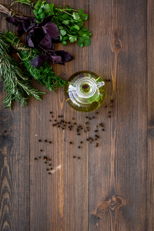 natural oil and fresh greenery for restaurant cooking with spices on wooden kitchen table background top view space for textの写真素材