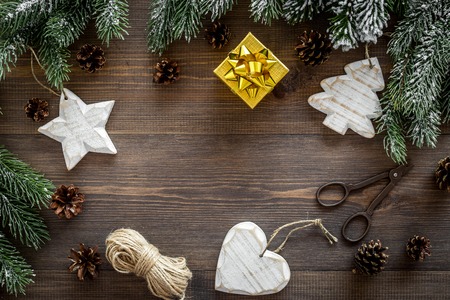 New year's background. Christmas toys, present, spruce branches, pine cones on dark wooden background top view.の写真素材