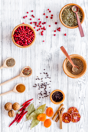 Variety of spices and dry herbs in bowls on wooden kitchen table background top view patternの写真素材